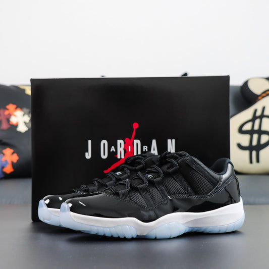 Air Jordan 11  Retro Low Space Jam. Black Jordan sneaker with white soles in front of a Jordan box on a dark surface.