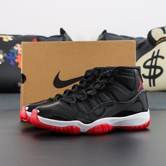 Air Jordan 11 Retro Playoff Bred. Black and red sneakers with a Nike box in the background
