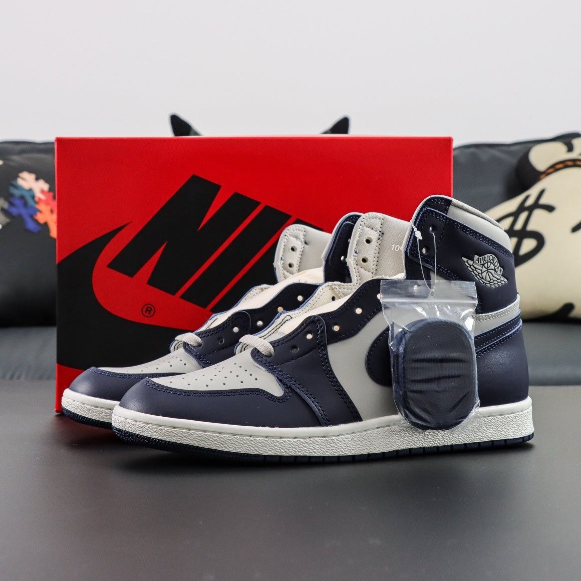 Air Jordan 1 Retro High OG 85 College. 
Navy and white sneakers with a red Nike box in the background