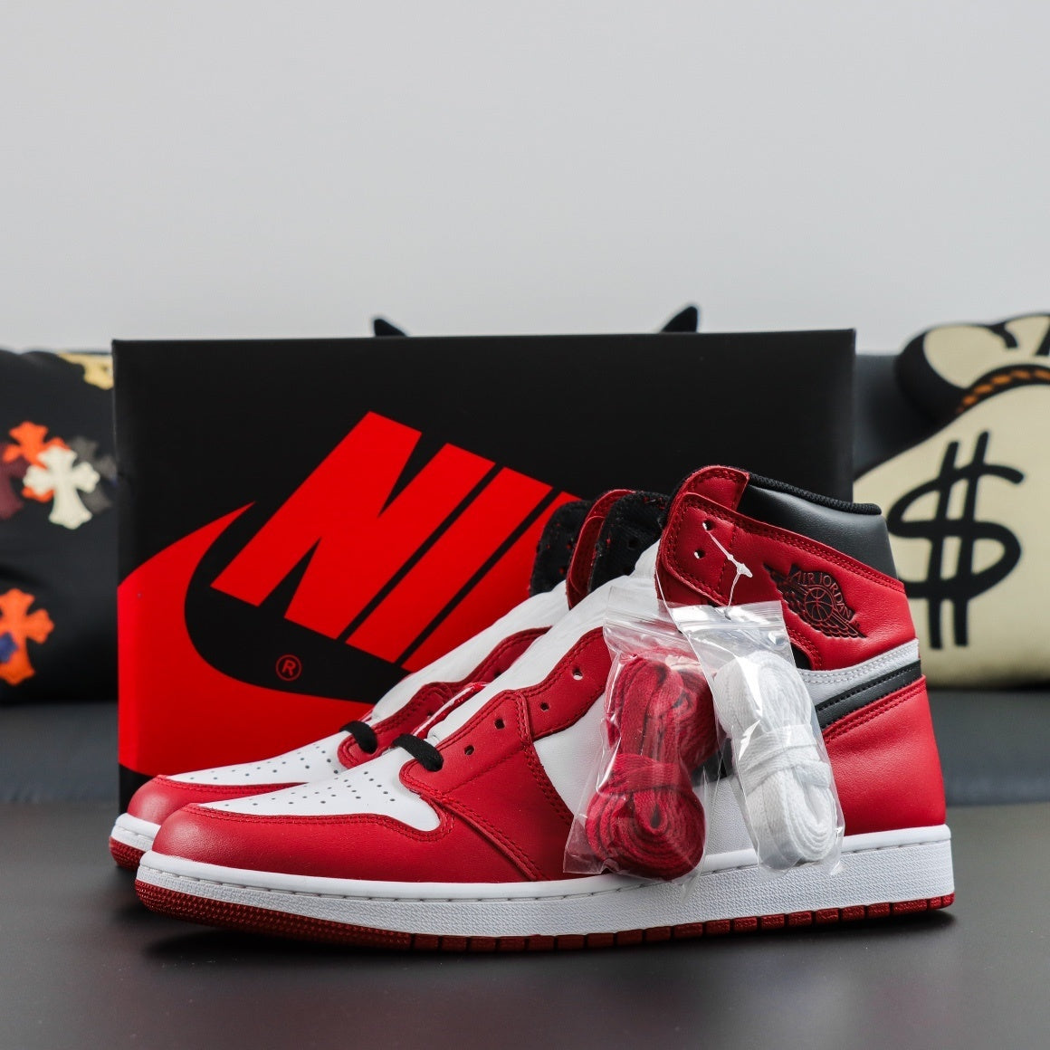 Red and white sneakers with a prominent brand logo on a gray surface. Air Jordan 1 Retro High OG Chicago 2015