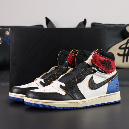 Black, white, red, and blue sneakers with a prominent Nike logo on a dark surface. Air Jordan 1 Retro High OG SP Fragment x Union LA Varsity Red Sport Royal