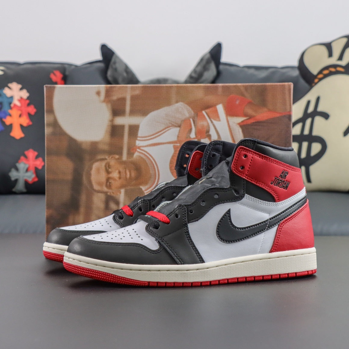Air Jordan 1 Retro OG High Black Toe Reimagined. Black, red, and white sneakers with a blurred background