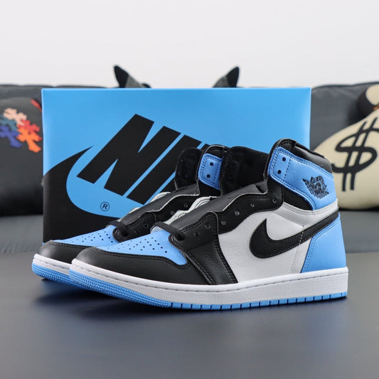 Air Jordan 1 Retro OG High UNC Black Toe. Black, white, and blue sneakers with a Nike box in the background
